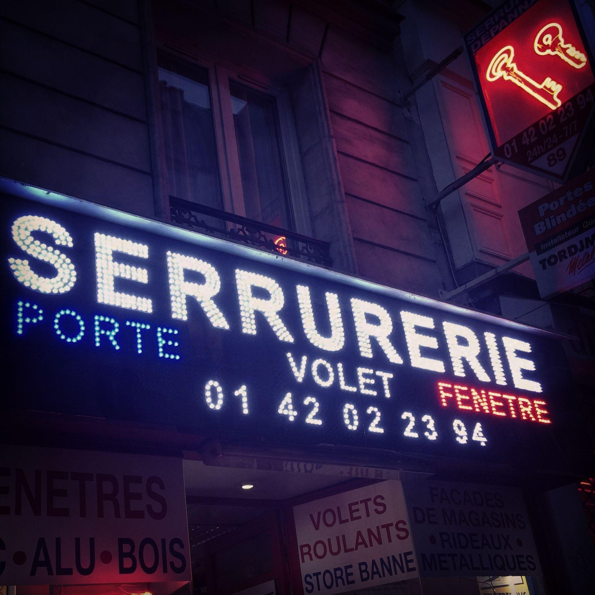 Enseigne lumineuse de la boutique de serrurerie Artisans Suprême, rue de Belleville, Paris 19e